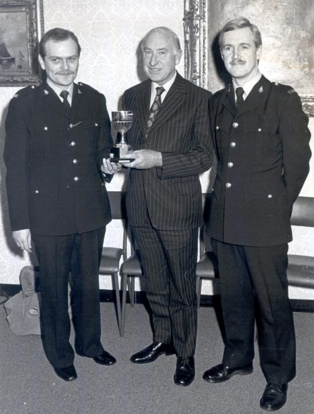 Mr Oscar Colburn Commander British Empire; Justice of the Peace; Deputy Lieutenant  presenting the Colburn Trophy to Police Constable Derek Donaldson  and with runner-up Police Constable Steve Norgate 1983. (Gloucestershire Police Archives URN 434)