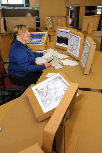 Force Control Room Operator Carol Sumner during refit exercise using cardboard desks in New Force Control Room 2013. (Gloucestershire Police Archives URN 10890-18)
